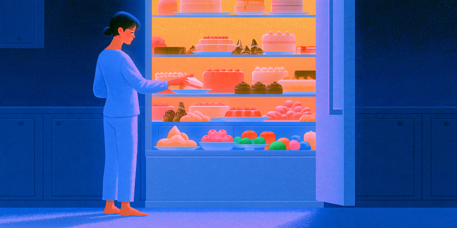 A woman in pale pyjamas stands barefoot in a dark kitchen at night, reaching into a brightly lit open fridge full of cakes and desserts.